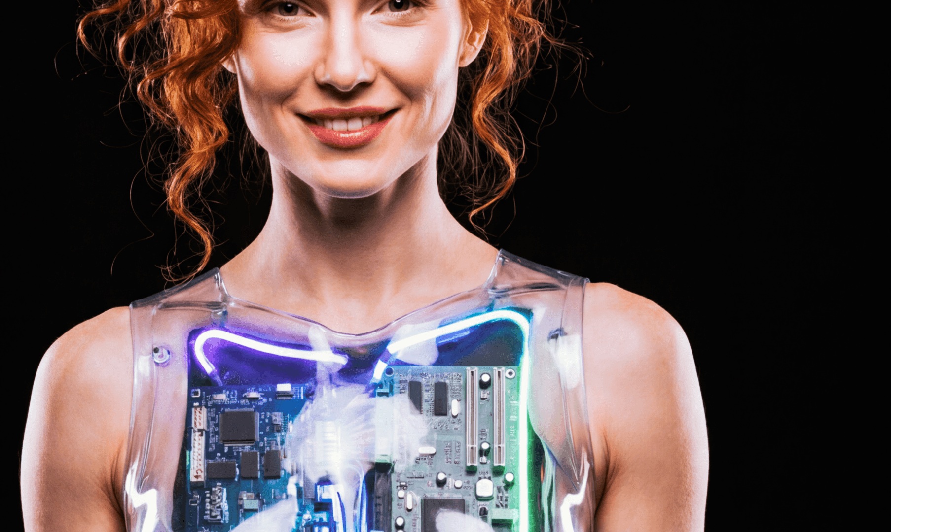 Smiling woman with red hair wearing a transparent chest piece revealing glowing internal circuitry.